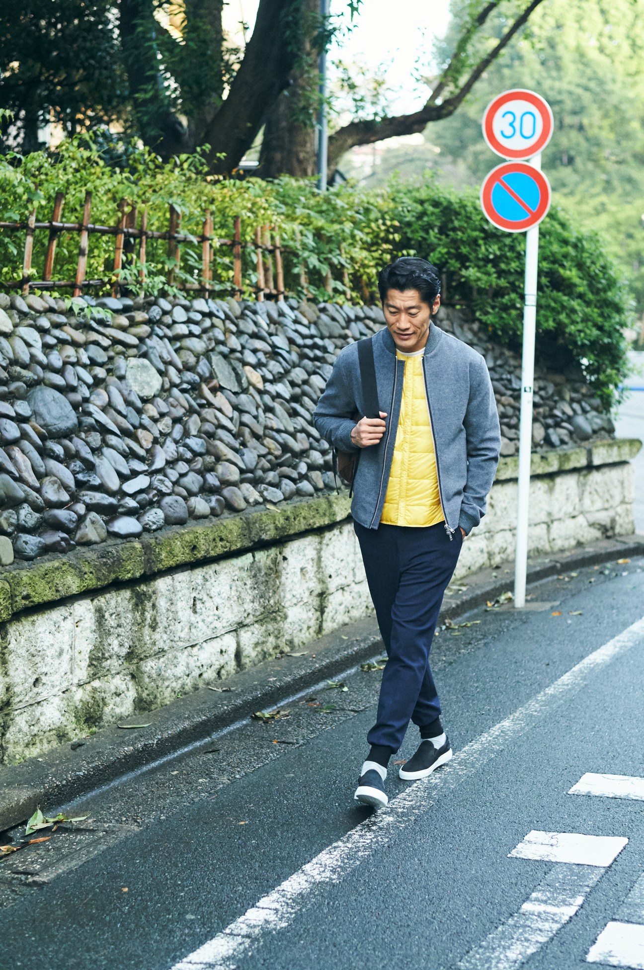 Man jogging on a Japanese rural road wearing Oliver Spencer jacket and Descente Allterrain down jacket.