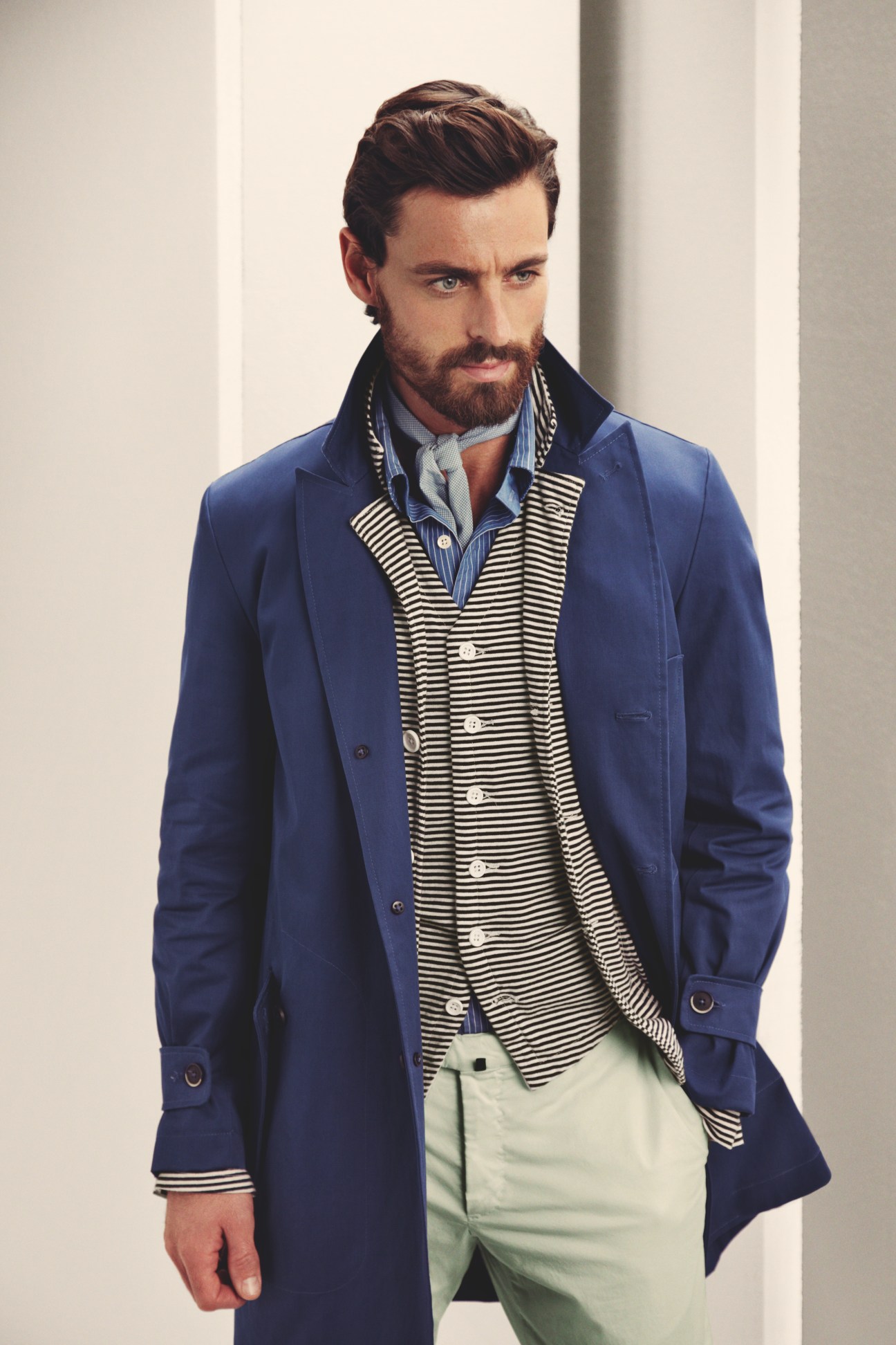 Man wearing navy Barena coat, Engineered Garments jacket and waistcoat, striped ts(s) shirt and tie, and Incotex trousers.