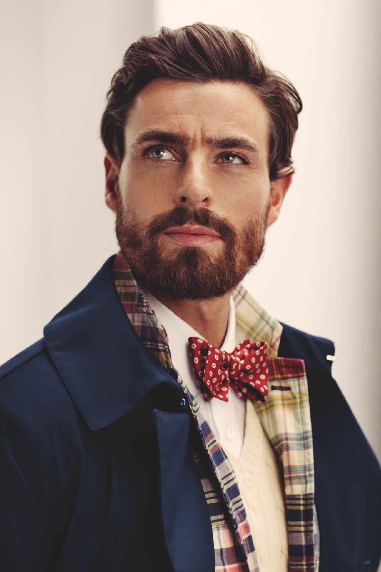 Man wearing navy Mackintosh coat, Polo Ralph Lauren jacket and waistcoat, Ermenegildo Zegna shirt, and Drake's bow tie.