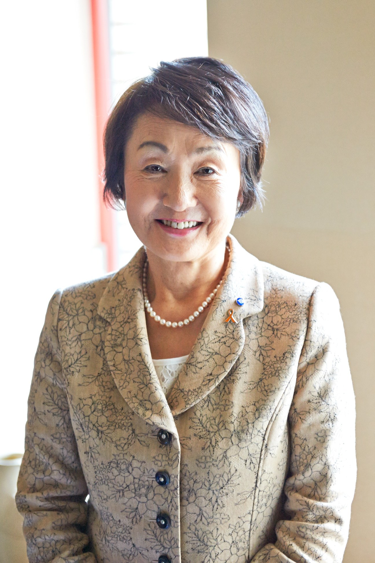 Fumiko Hayashi, mayor of Yokohama, smiling in a patterned beige blazer and pearl necklace.