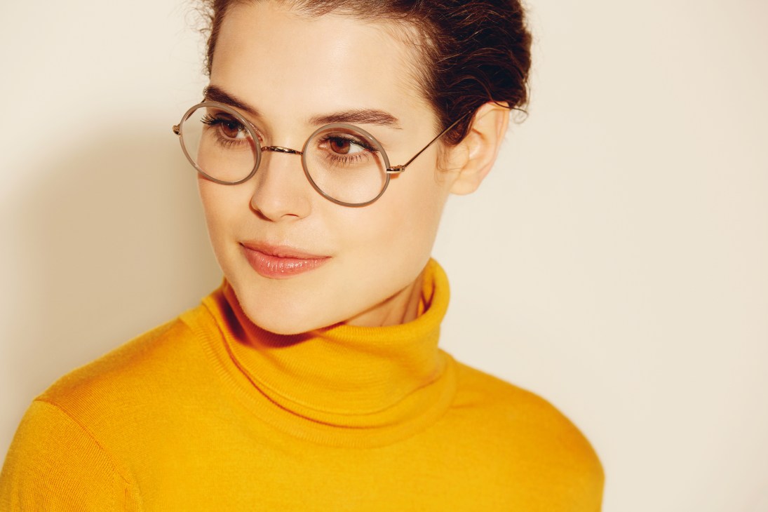 Person wearing round tortoiseshell-framed glasses and a mustard-yellow turtleneck sweater.