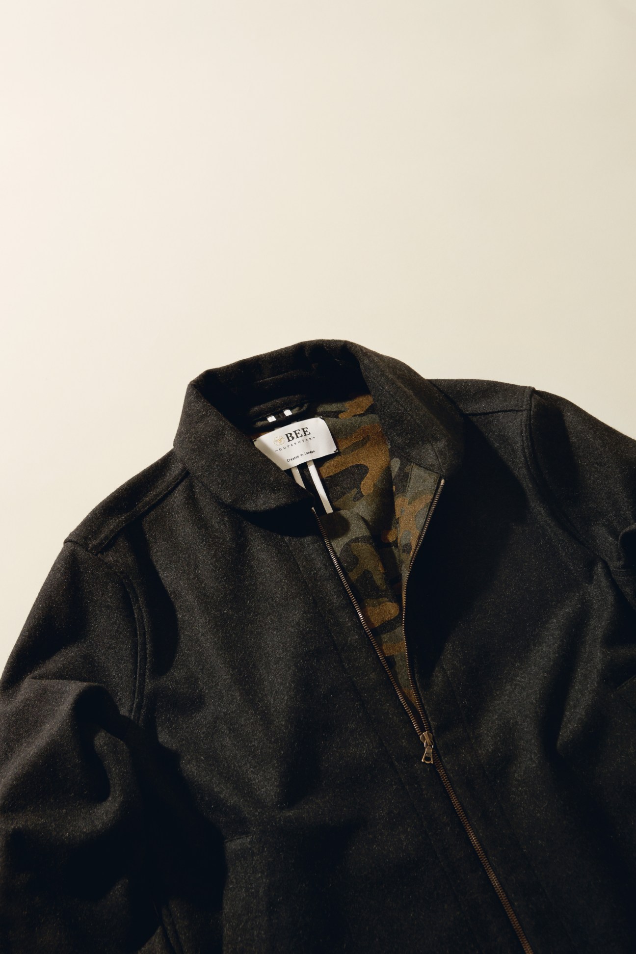 Charcoal grey wool jacket by Bee Clothing with patterned lining and metal zip closure.