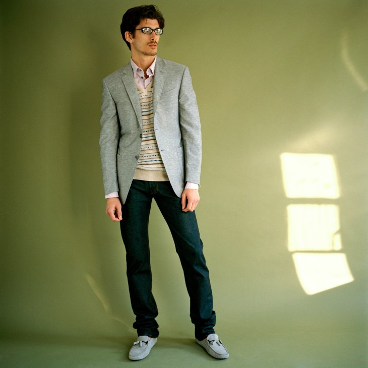 Man wearing Canali jacket, Hackett jumper, and APC shirt against yellow-green background.