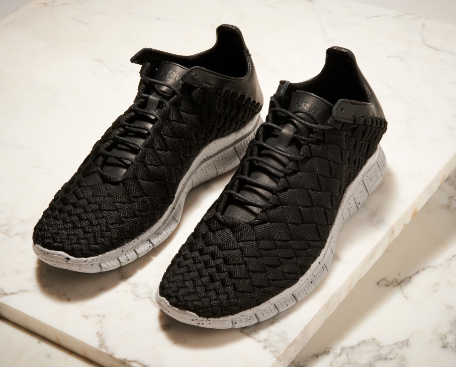 Pair of black Nike Inneva Woven trainers with white soles on marble surface.