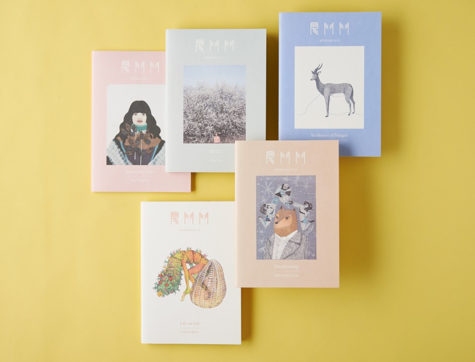 RMM ArtBooks booklets displayed on a yellow background featuring artwork and pastel-colored covers.