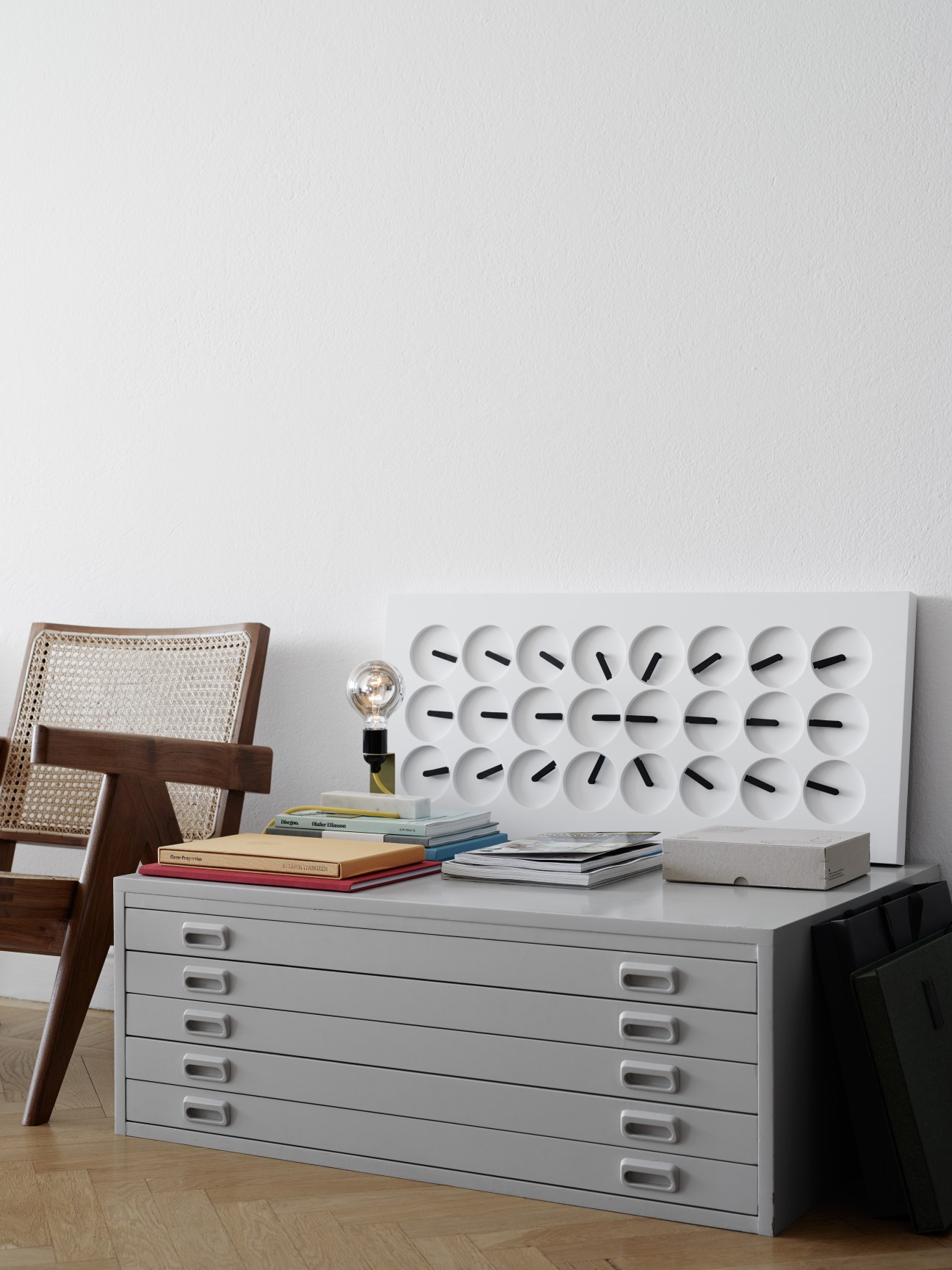 AML Reflector Lamp on gray flat file cabinet with books and cane chair