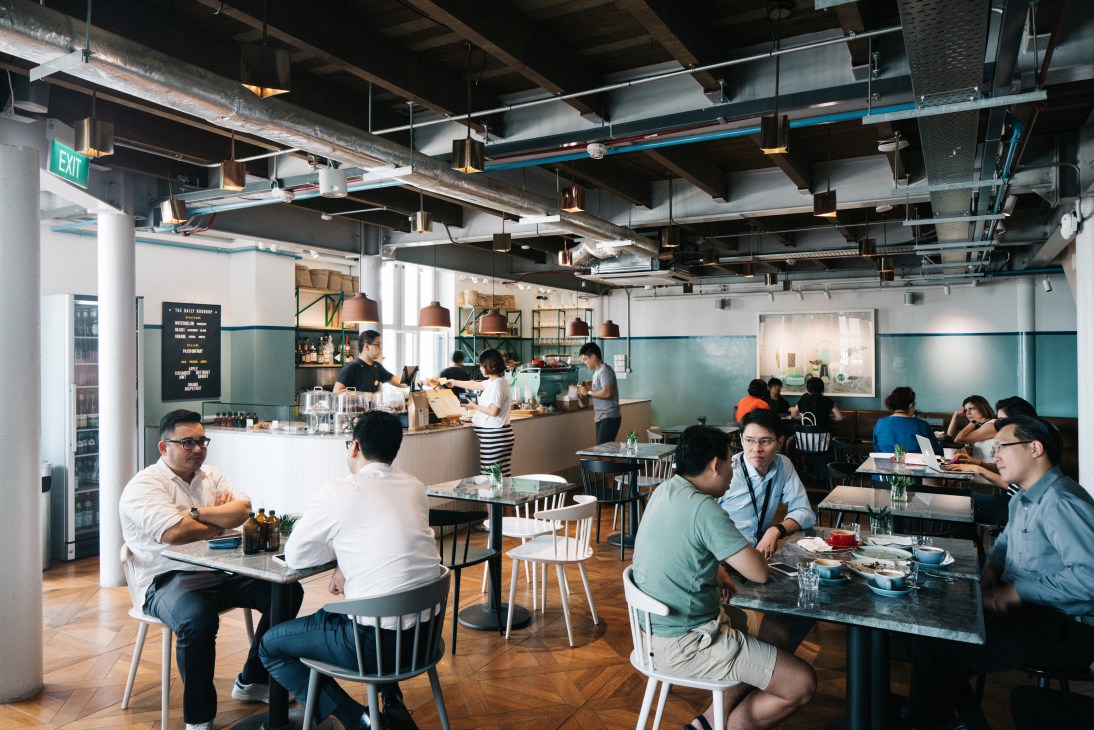 Interior of The Populus café in Duxton Hill with customers seated at tables and staff at the counter.