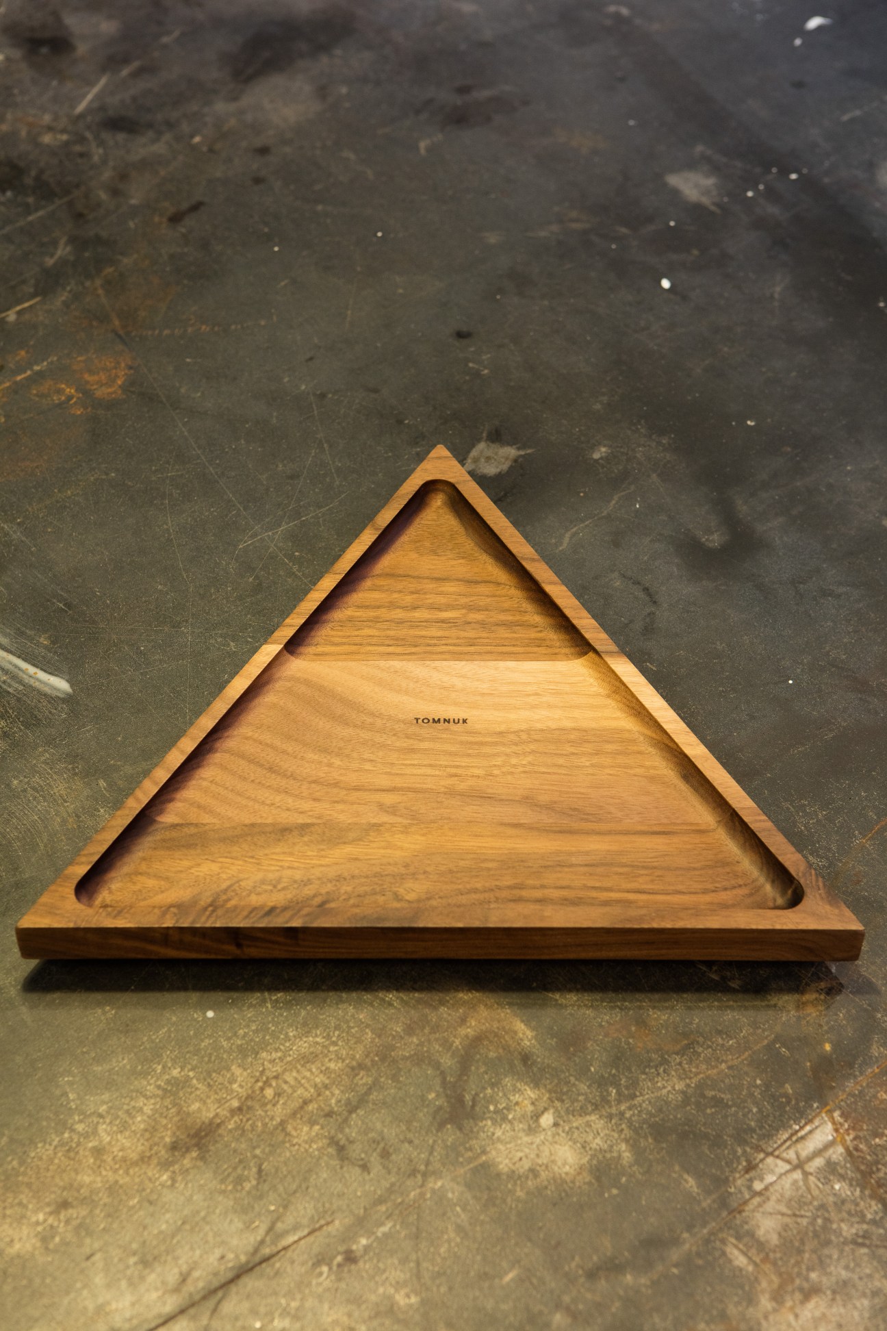 Triangular wooden tray with natural wood grain and Tomnuk branding