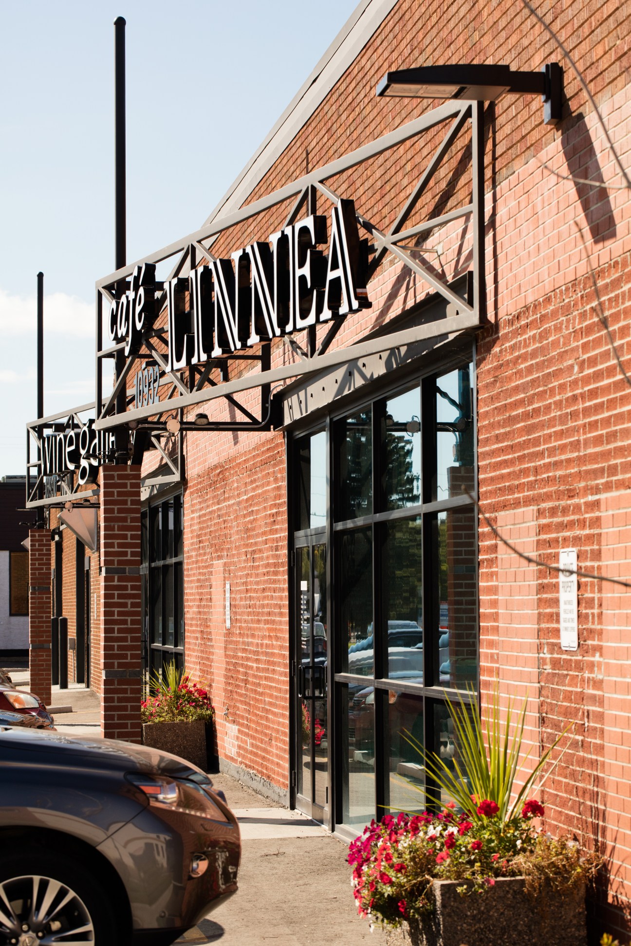 Café Linnea exterior with brick building, black metal signage, and glass storefront with flower planters