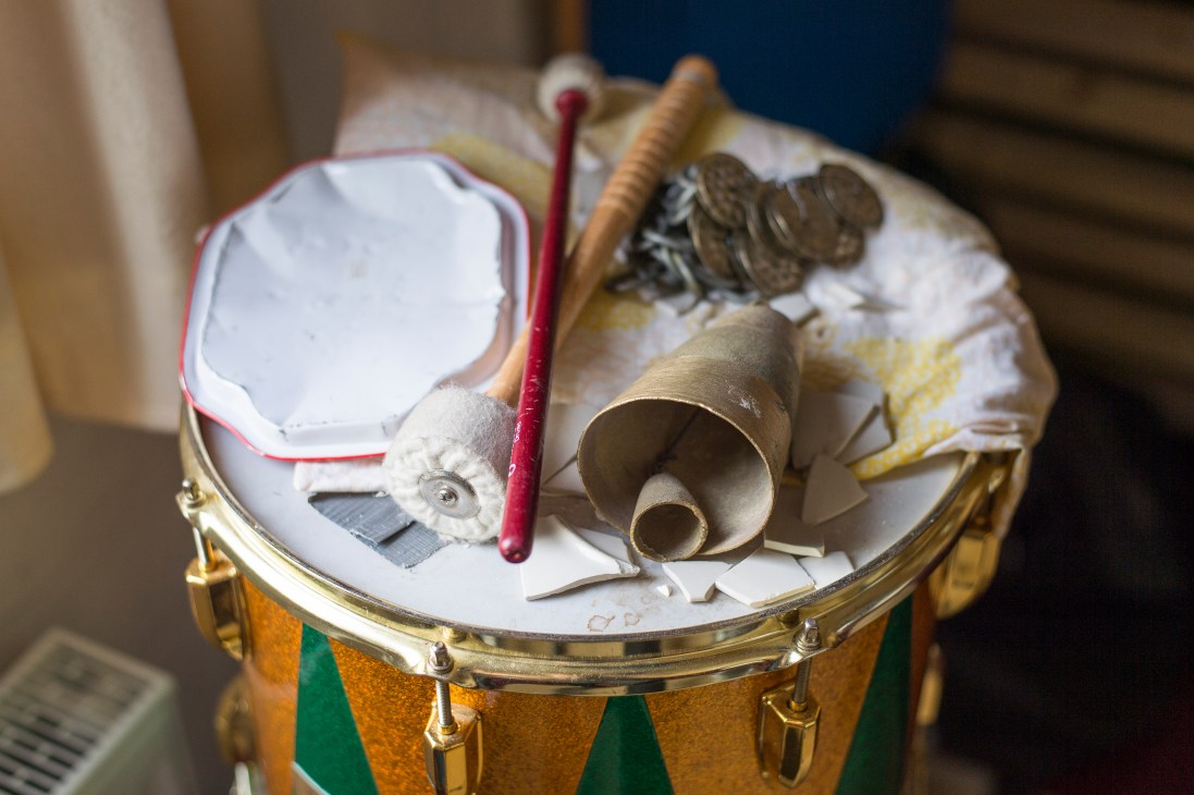 Drum with various percussion instruments and mallets arranged on top