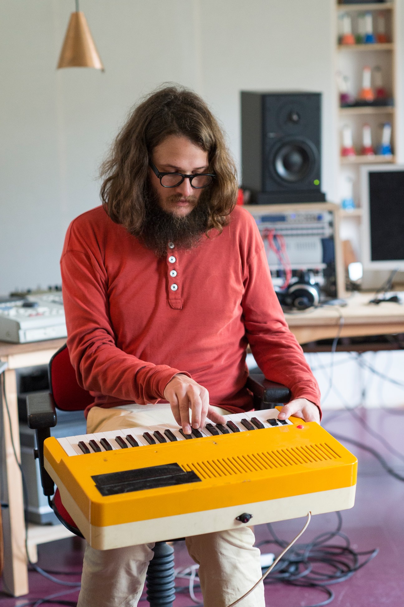 Mads Brauer plays a yellow keyboard synthesizer in Efterklang's Berlin studio.