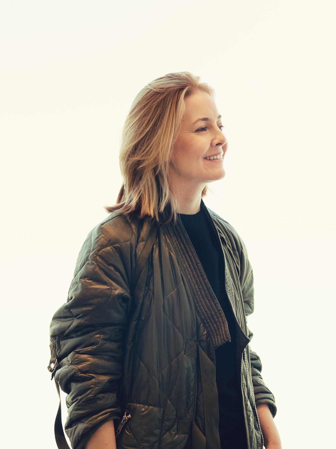 Elizabeth Dee, co-founder of Independent art fair, smiling in profile against a white background.
