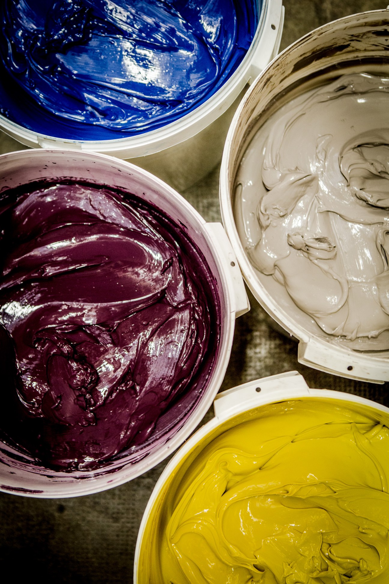 Four buckets of Famaco shoe cream in blue, burgundy, beige, and yellow colors.