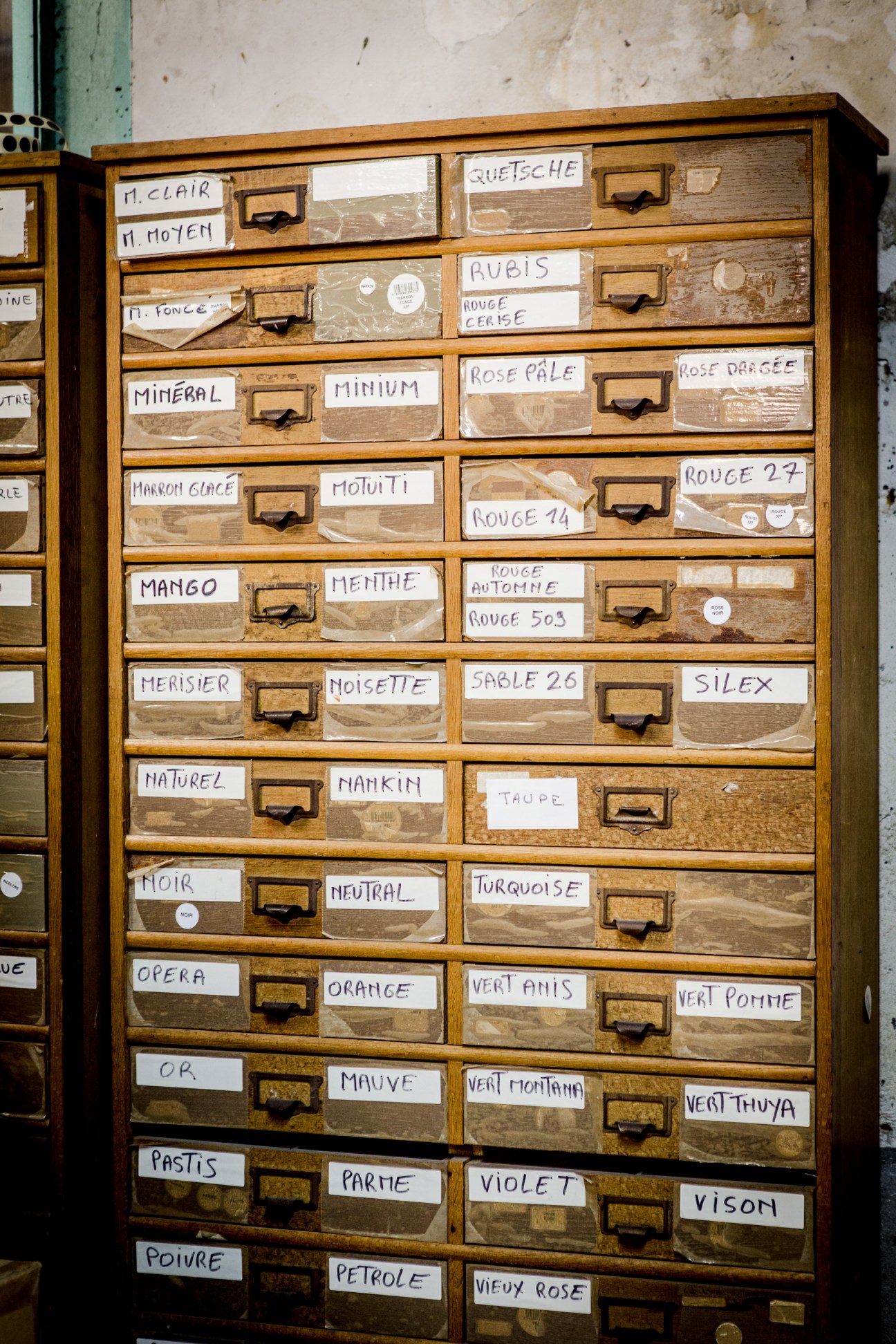 Wooden apothecary drawers with hand-written labels containing different shades of Famaco shoe cream colours.