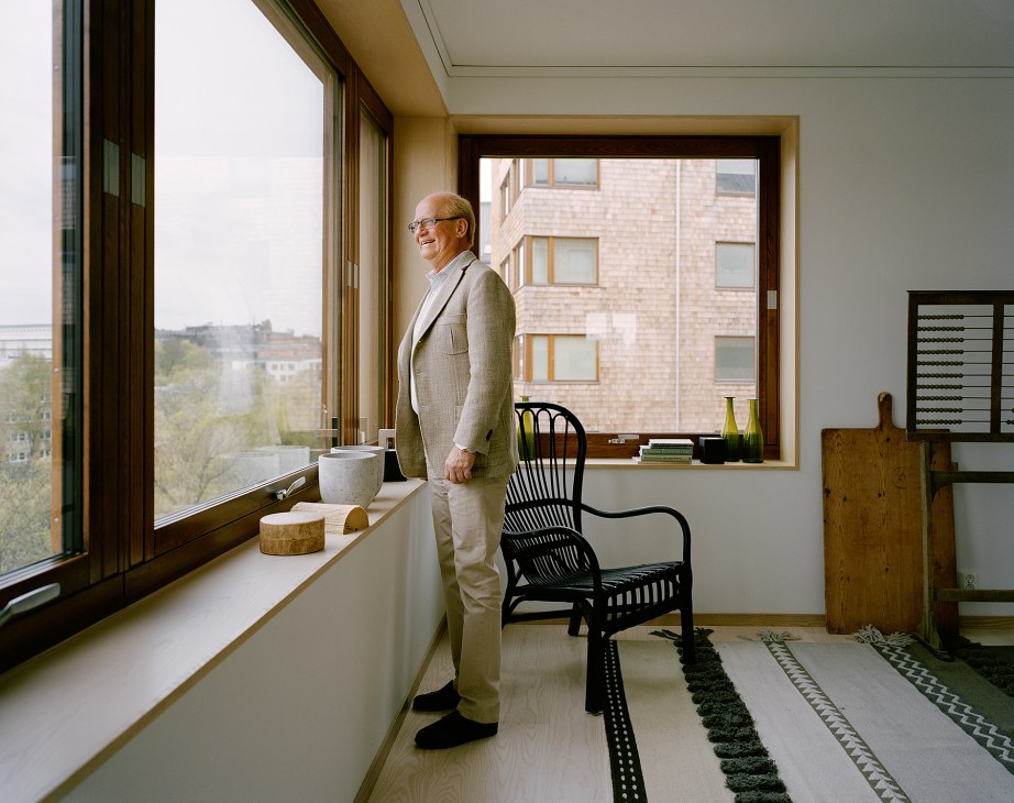 Arne Olsson stands by a window in his Strandparken apartment, gazing at Stockholm views.