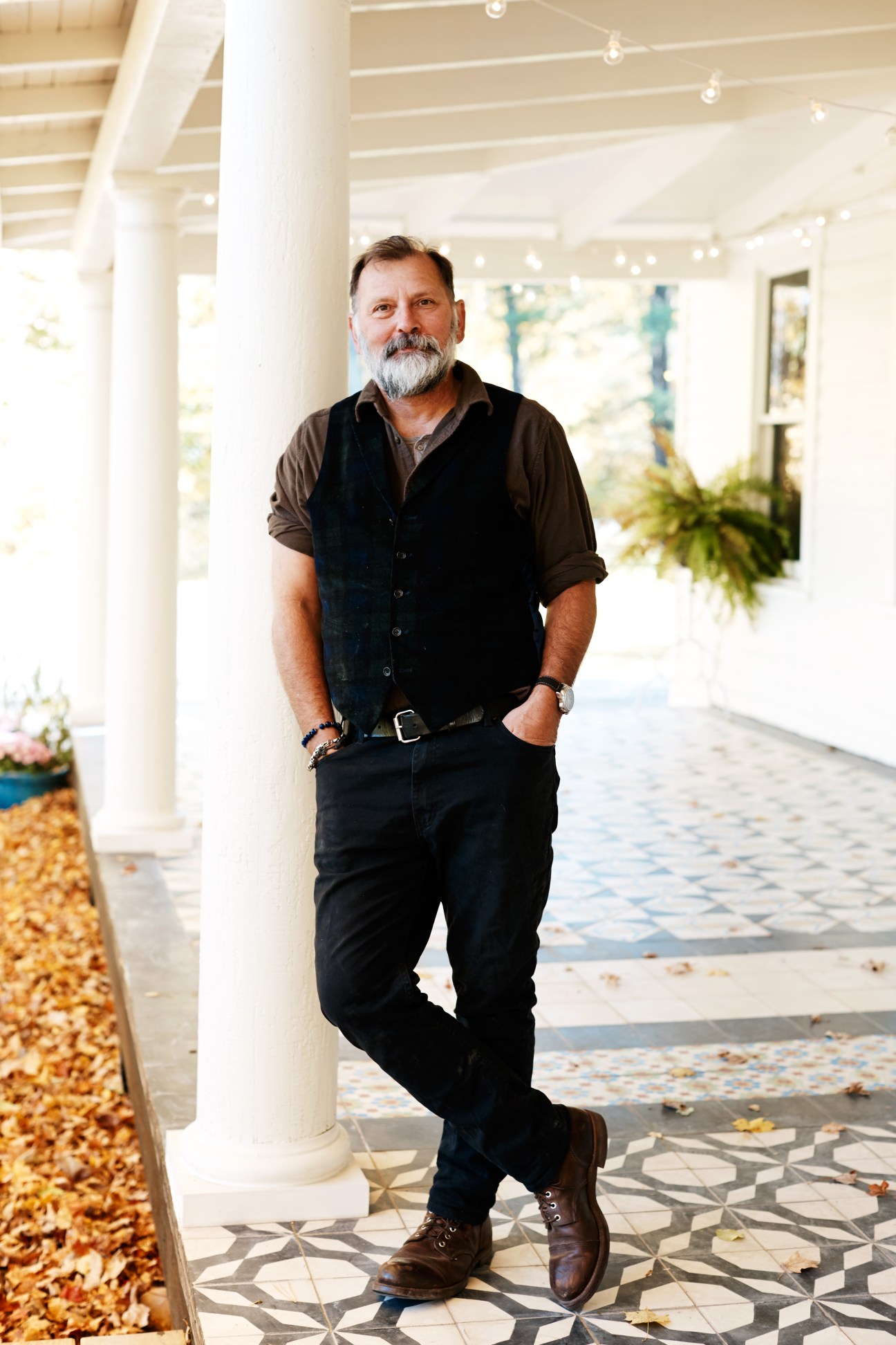 Man with grey beard standing in a bright white colonnade at Foxfire Mountain House.