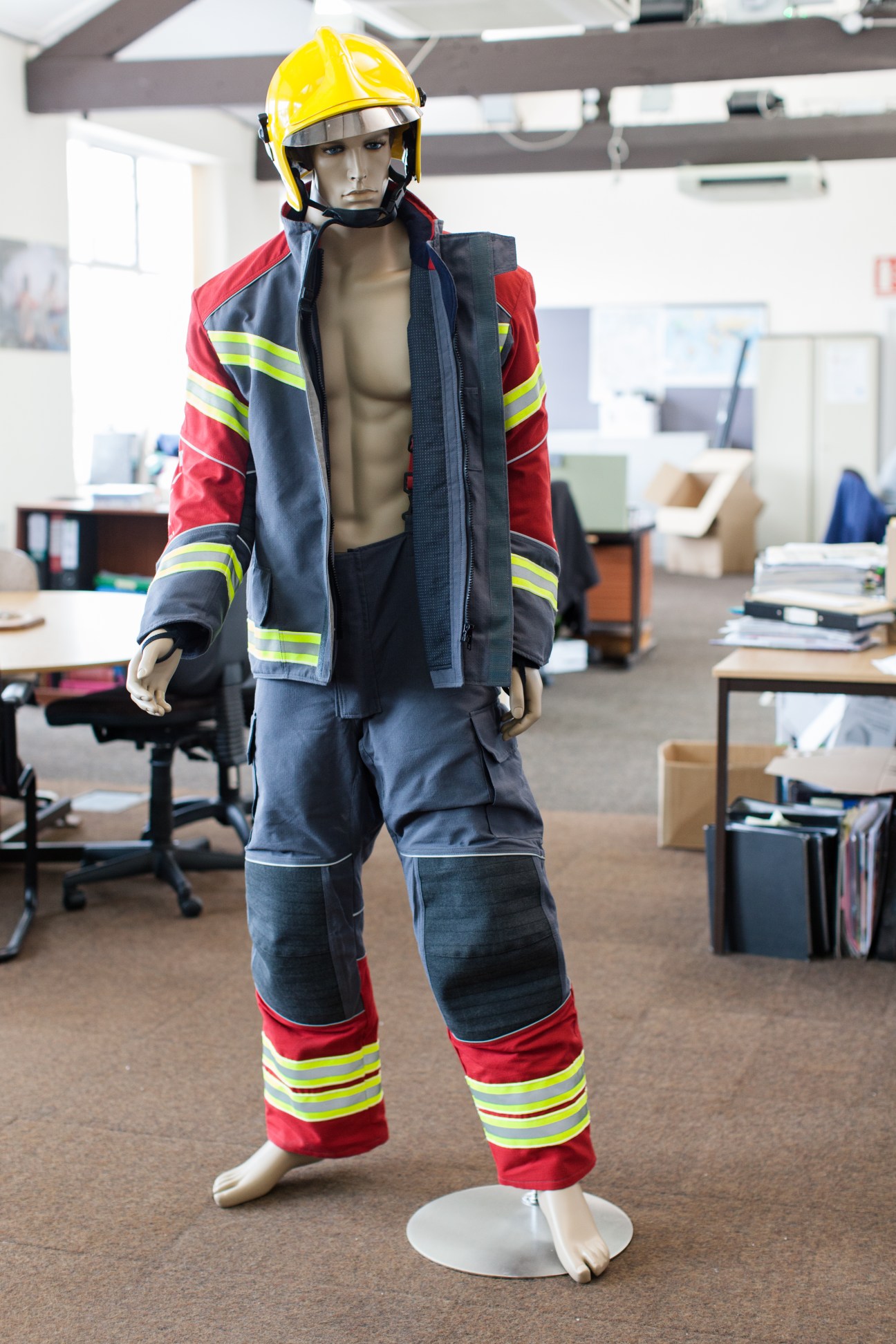 Mannequin wearing firefighter uniform with Hainsworth Eco-Dry fabric jacket and pants with reflective stripes and yellow helmet.