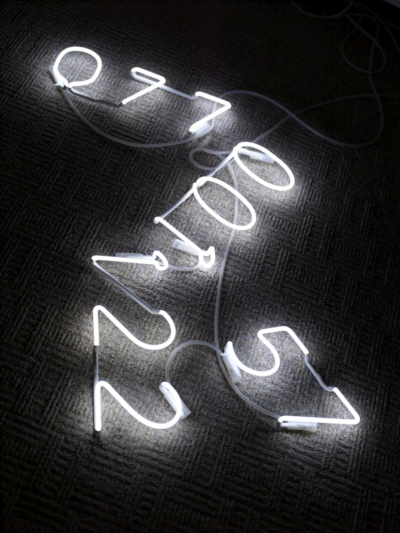 Neon light spelling out a phone number on dark textured surface