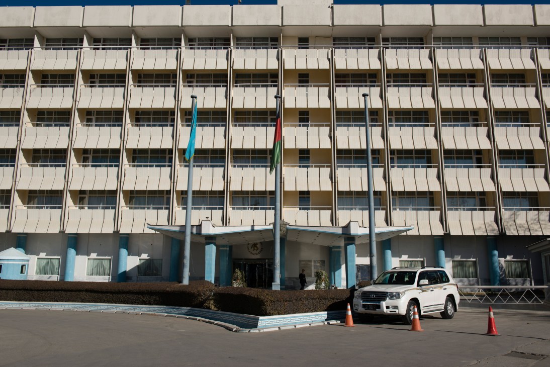 InterContinental Kabul's modernist facade with blue-painted ground floor and multi-story concrete structure featuring repetitive window pattern.
