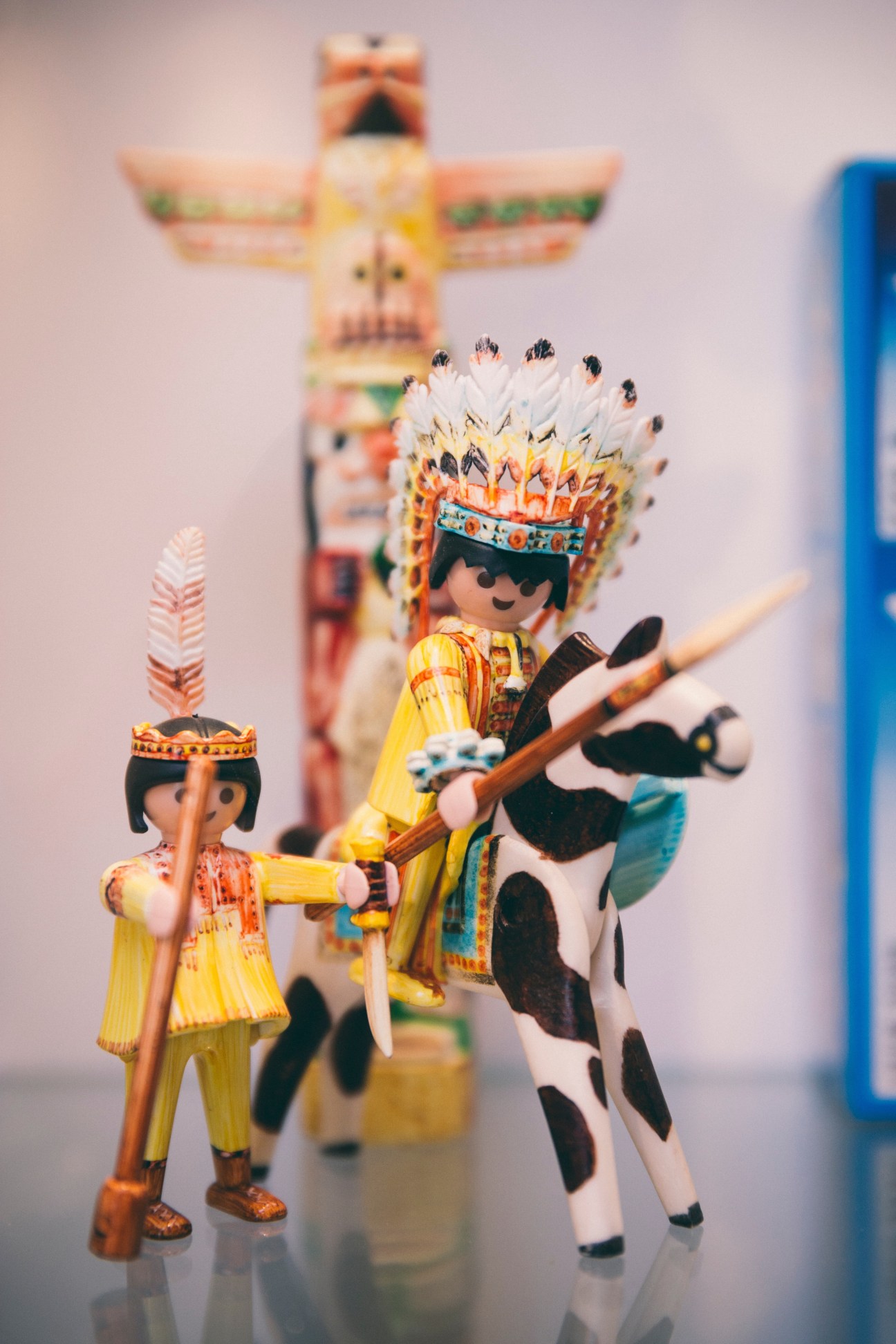 Playmobil Native American figures with feathered headdresses and traditional clothing holding accessories.