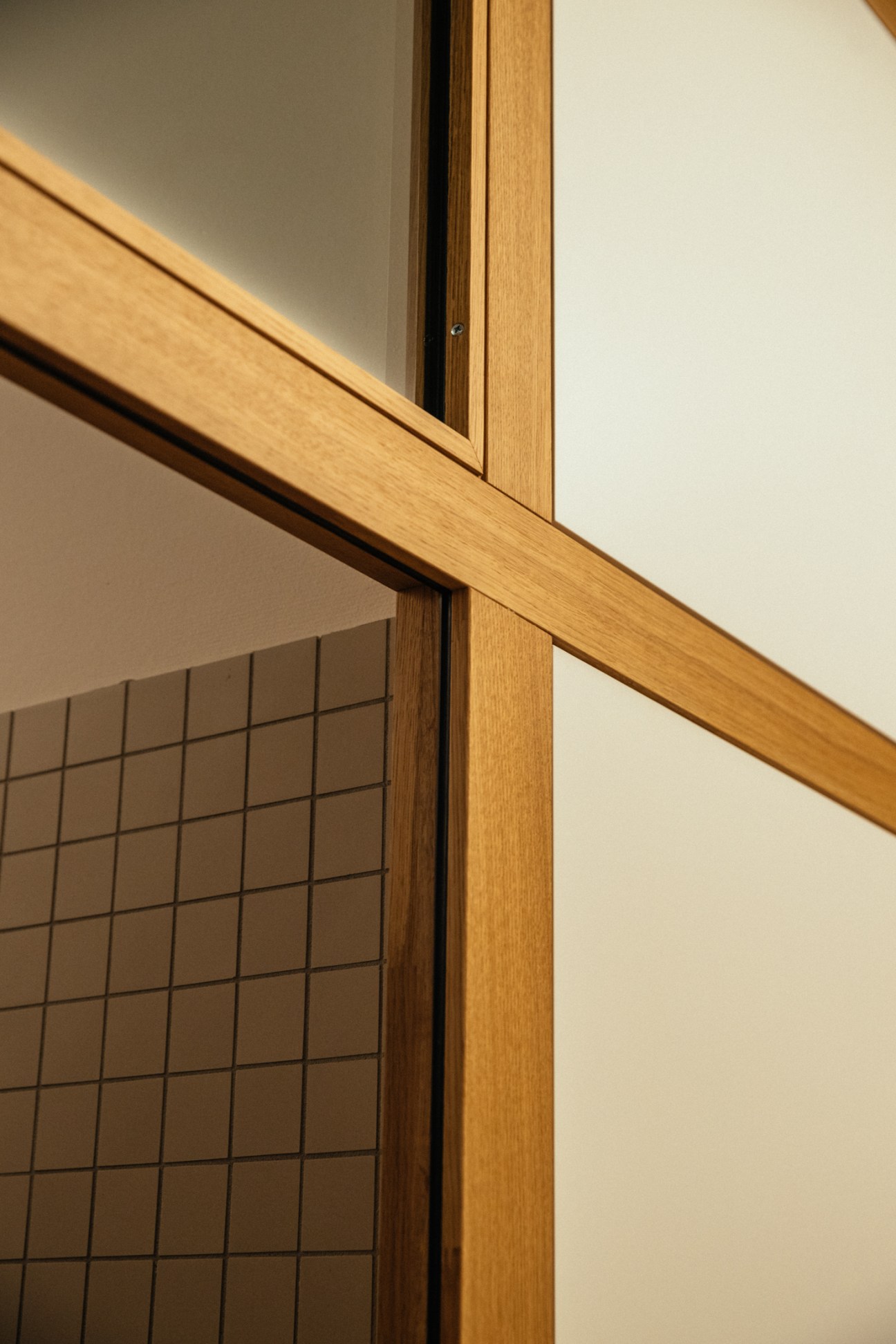 Oak wooden frame and transom detail of a window with gridded glass panes in Zofingen school.