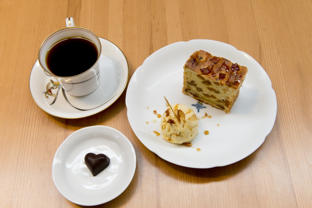 Coffee cup, pineapple pound cake, ice cream and chocolate heart on wooden table at SheMe House café.