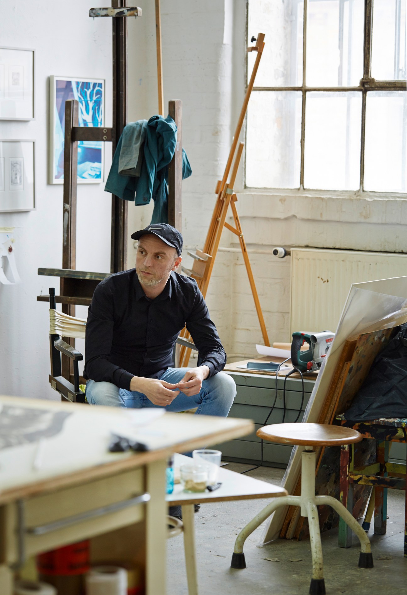 Sebastian Burger sits in his Leipzig studio surrounded by woodworking tools and equipment.