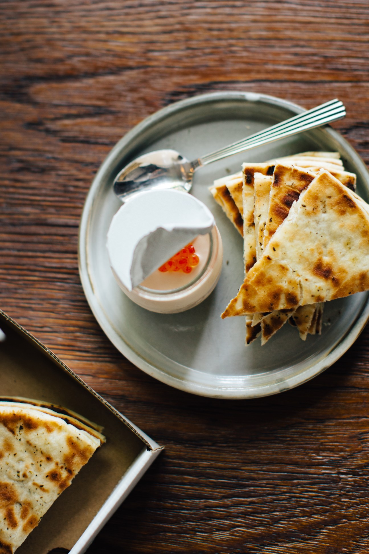 Taramasalata with mullet roe served with pitta bread on a white plate with fork.