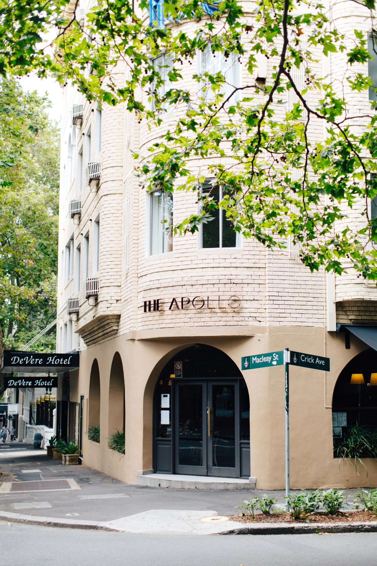 The Apollo restaurant entrance on Macleay Street in Sydney, with ivy-covered brick facade and street signage.