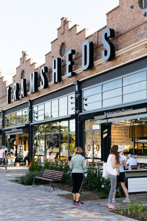 The Tramsheds storefront with ornate brick facade and large signage welcoming visitors to the Sydney food market hall.