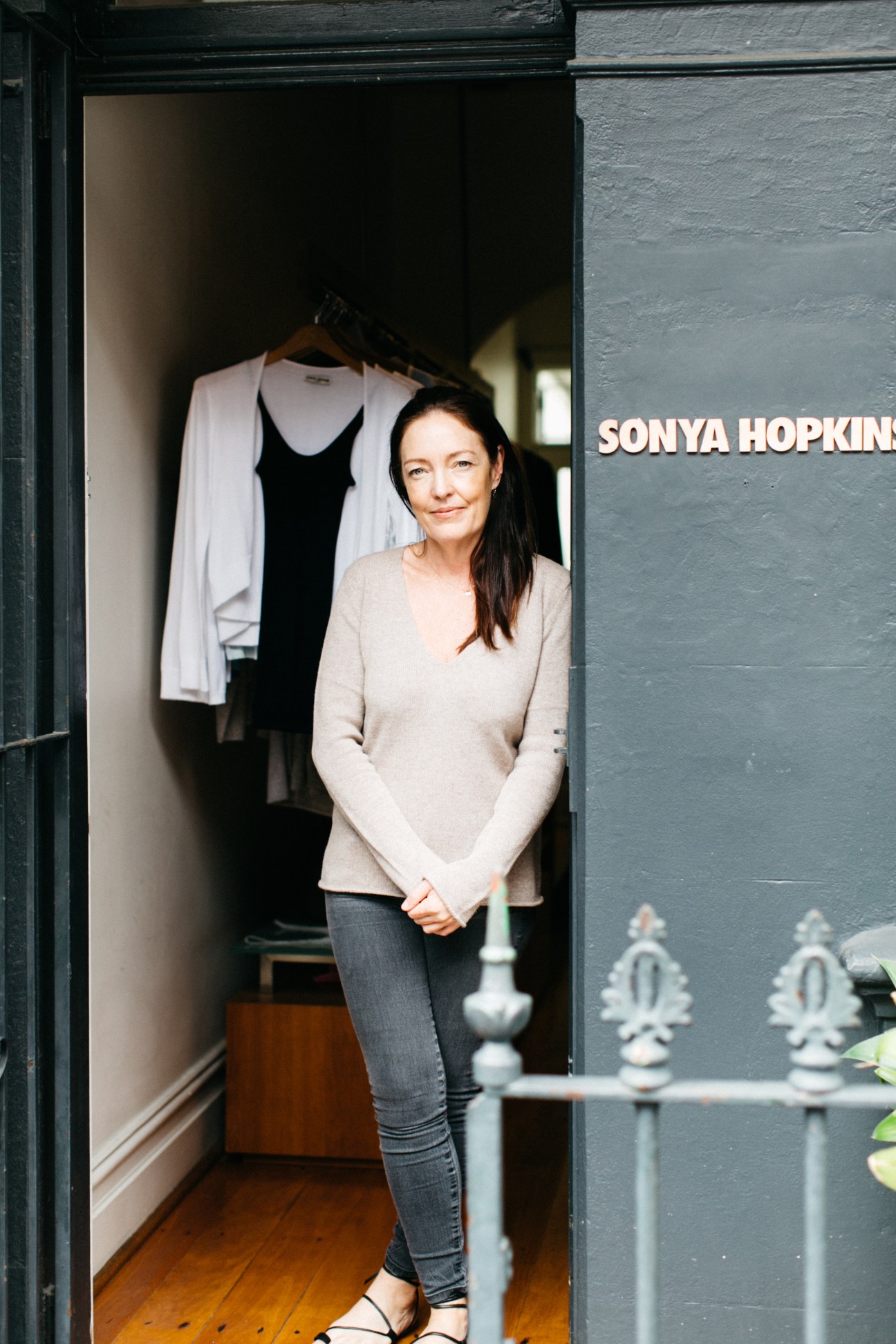Sonya Hopkins standing in the doorway of her Sonya Hopkins store on William Street, with knitwear displayed behind her.