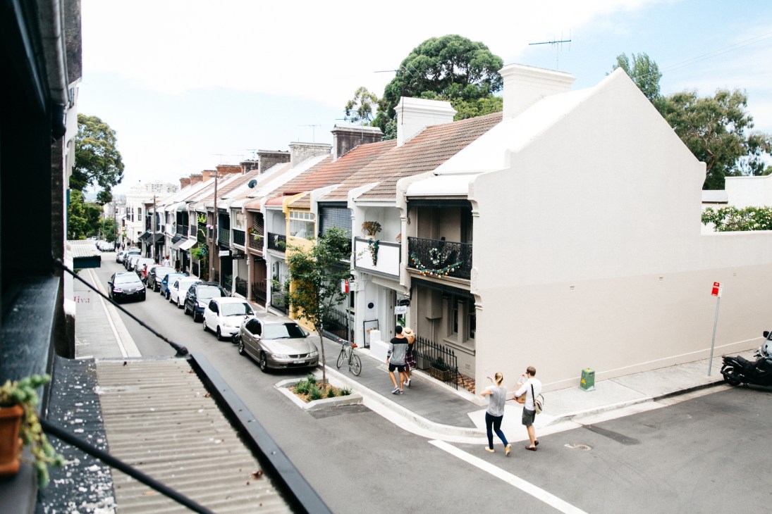 Aerial view of William Street in Paddington, Sydney, showing Victorian terraced houses converted into retail shops with pedestrians and parked cars.
