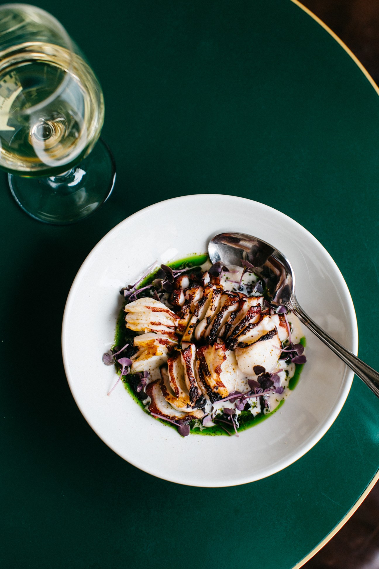 Plated octopus dish with greens and sauce at 10 William Street restaurant.