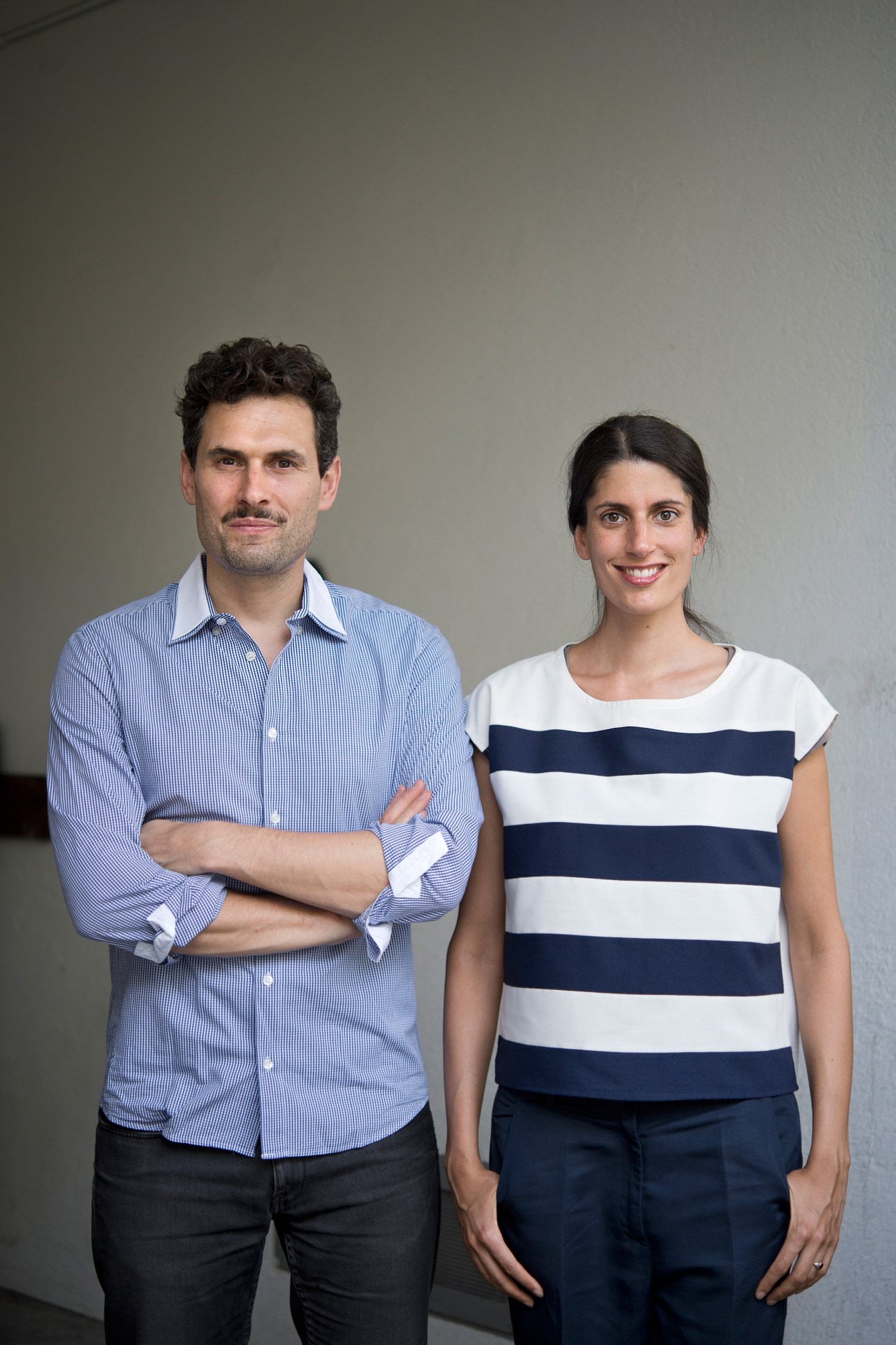 Donovan Gregory and Regina Schibli, owners of Fabrikat, stand together against a neutral background.