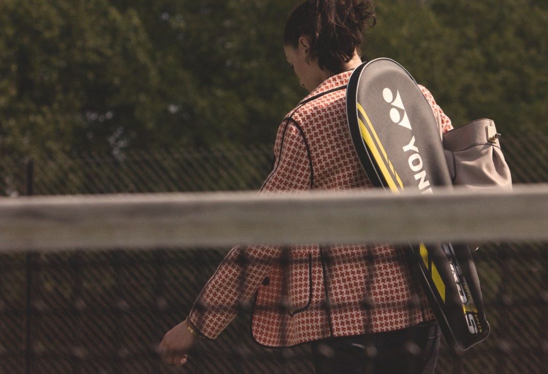 Tennis player wearing Aquascutum jacket and Yonex racquet bag at Parliament Hill Fields courts.