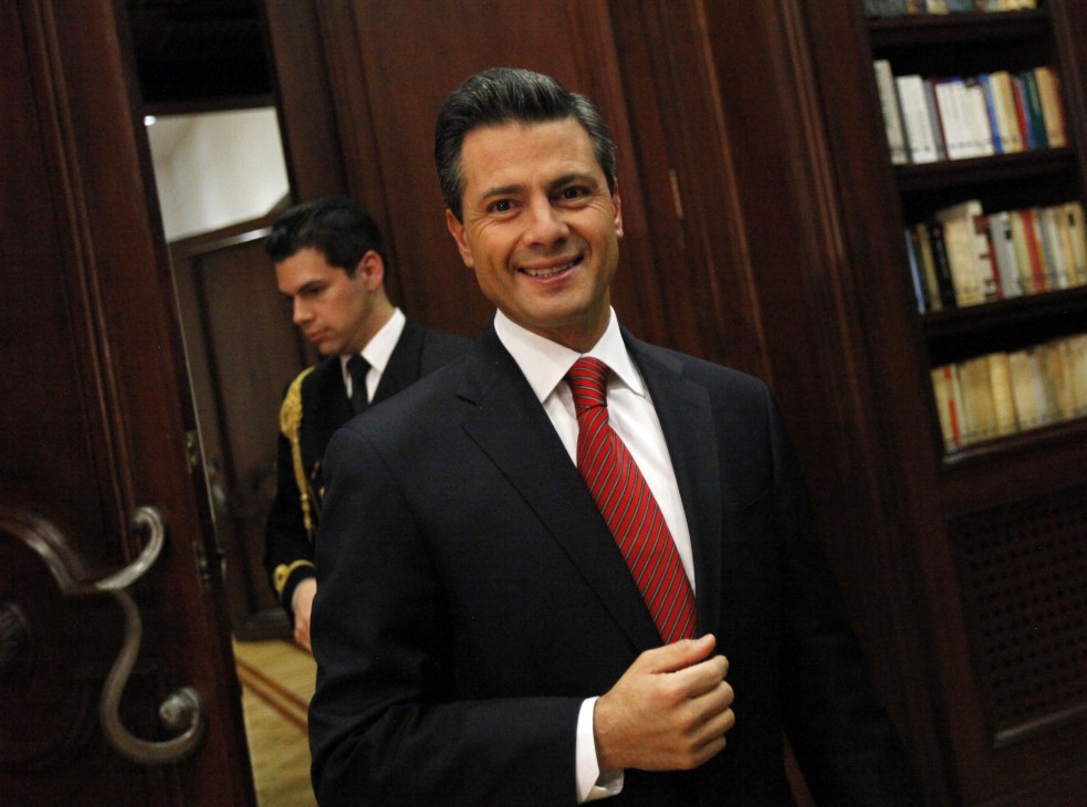 Enrique Peña Nieto in formal business attire with red striped tie in an ornate wood-paneled office.