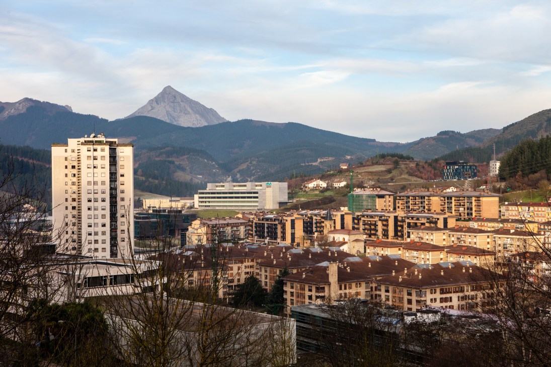 Mondragón town nestled in a Basque valley with mountains, residential buildings, and industrial structures.