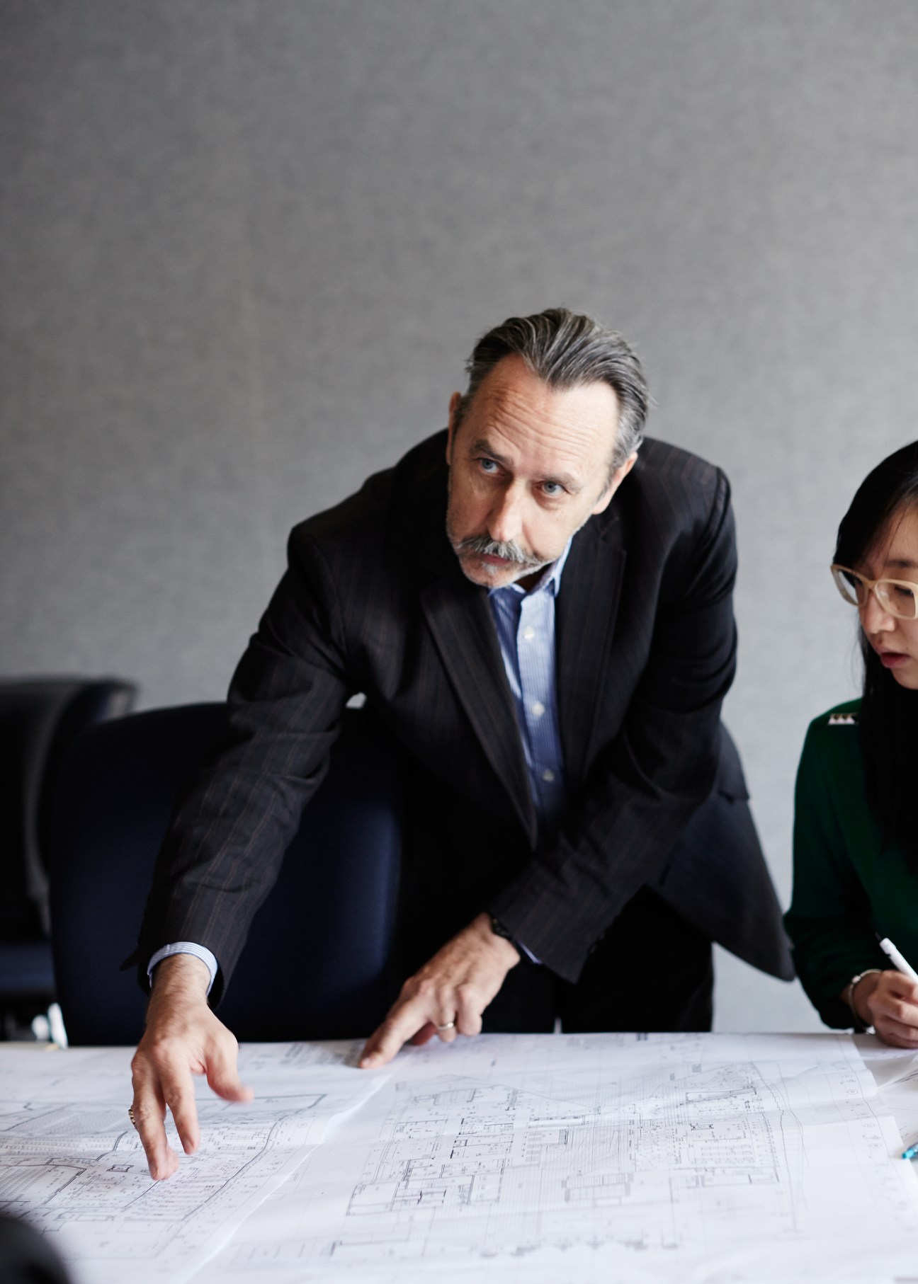 Professor Donald Bates reviews architectural plans at a table.