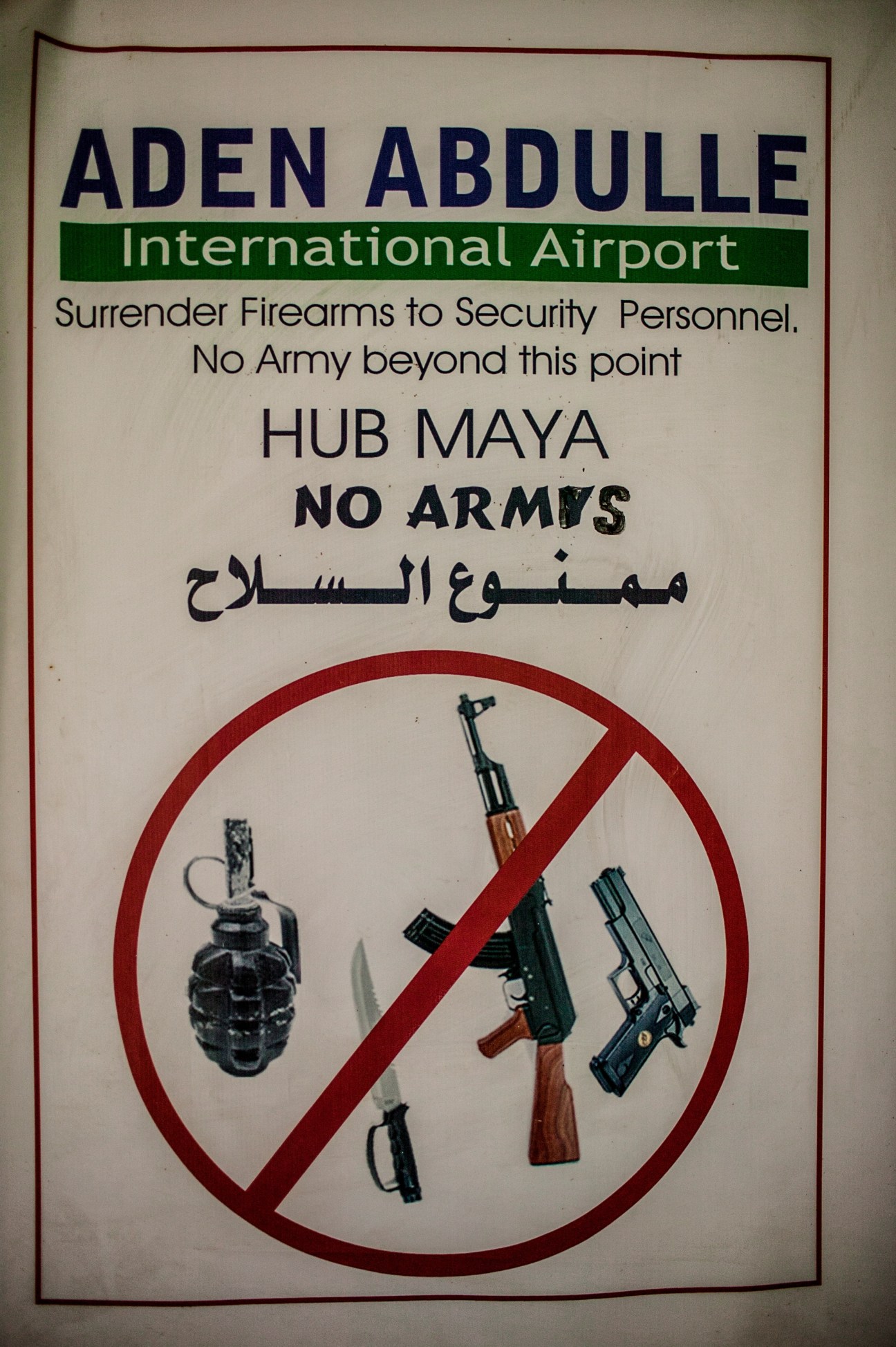 Aden Abdulle International Airport security poster banning weapons with no-entry symbol over firearms and grenades.