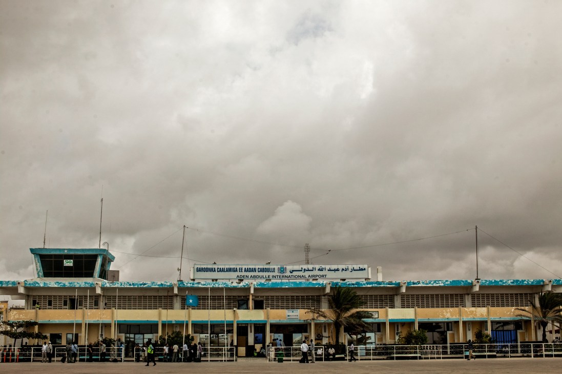 Aden Abdulle International Airport terminal building with turquoise trim under overcast sky in Mogadishu, Somalia.