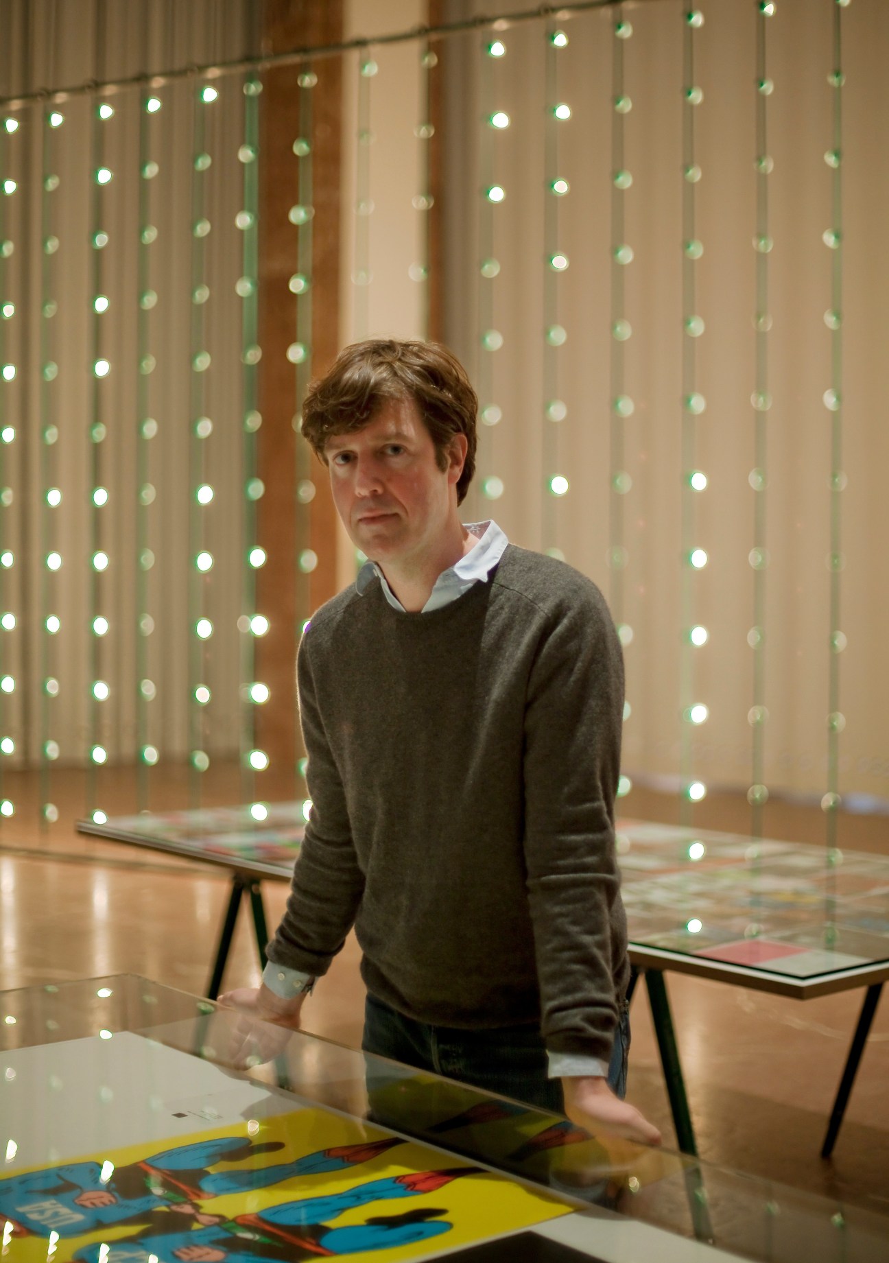 Graphic designer Thomas Mayfried stands in front of a beaded curtain at the Haus der Kunst museum.
