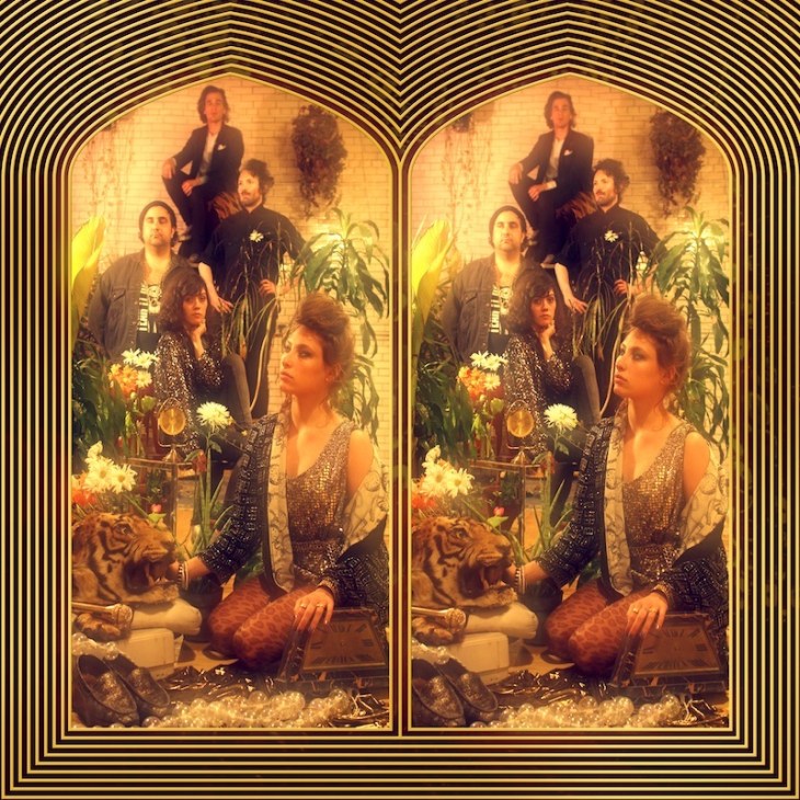 Album cover for Manifest! by Friends featuring five band members posed in a warm-toned, ornate interior with plants and flowers.