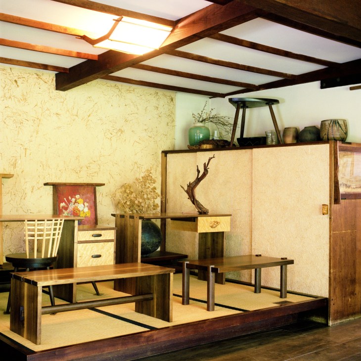 Nakashima furniture pieces displayed in an office showroom with wooden tables, chairs, and storage units.