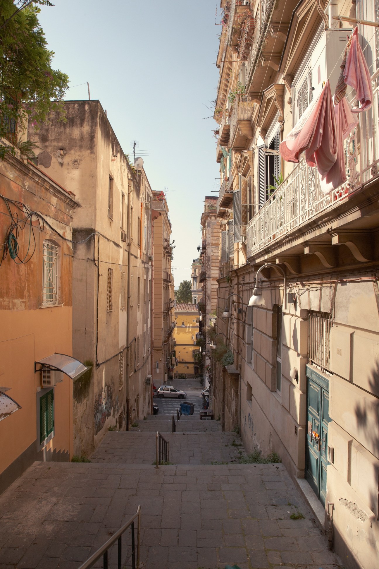 Narrow Spaccanapoli street in Naples with historic buildings and laundry hanging from balconies.