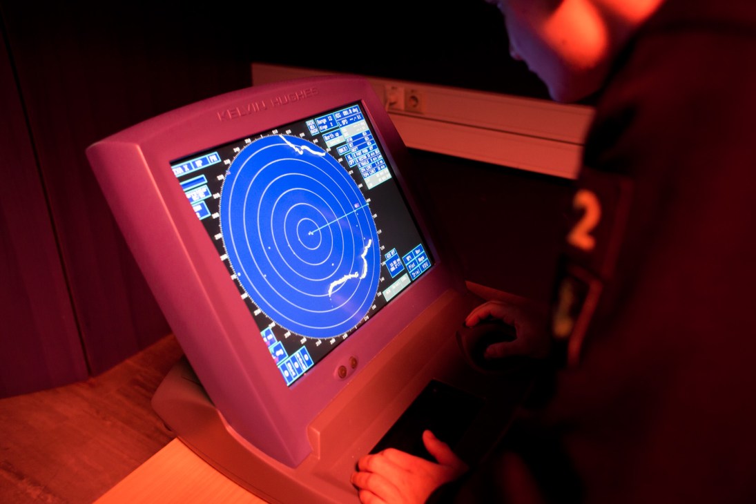 Pink radar training simulator with blue circular display showing concentric circles on screen.