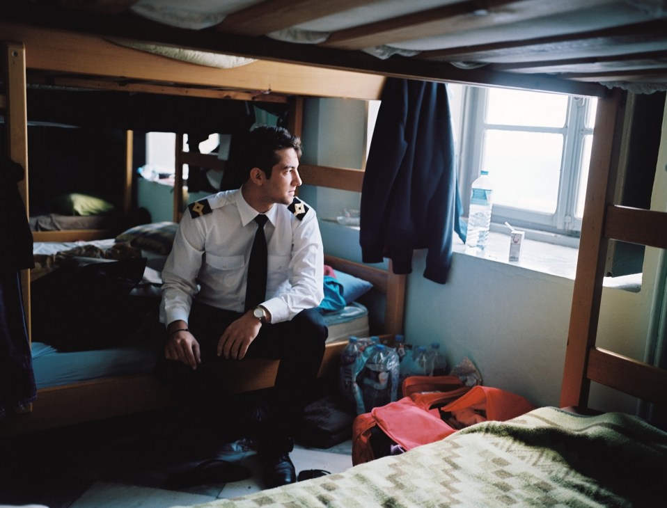 George Pandis, a merchant marine student, sits on his bunk bed in a cramped dormitory room at Hydra's naval academy.