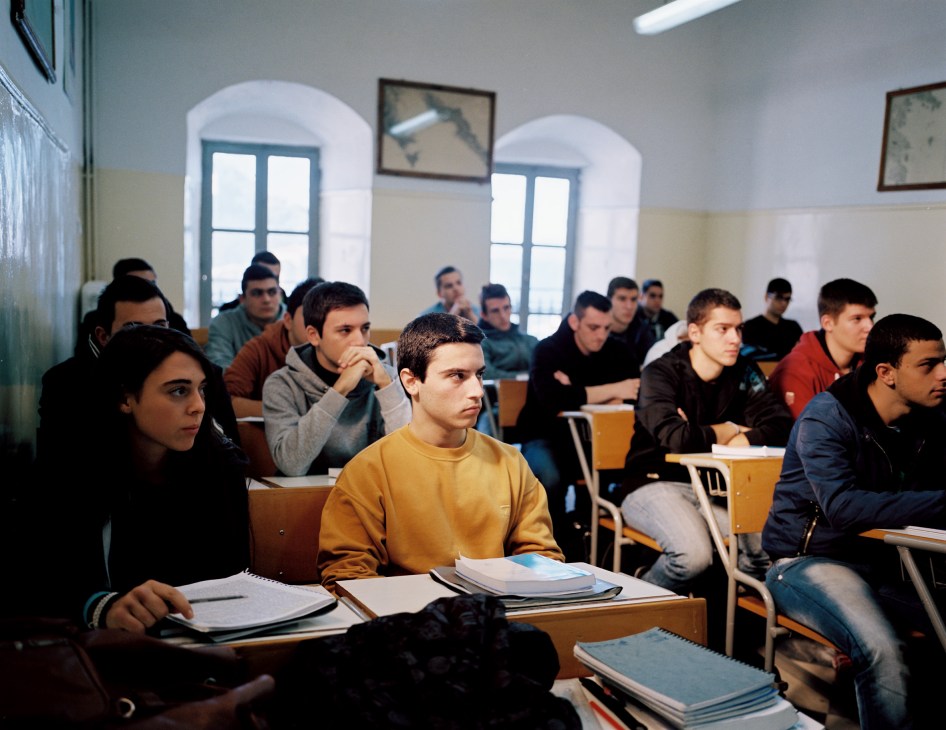 Merchant marine academy students sit attentively at desks during a classroom lesson.