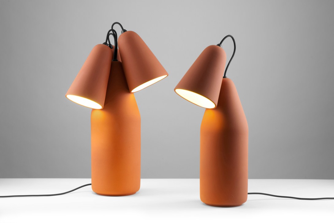 Two terracotta table lamps with cone-shaped shades and black cords by Slovak designer Tomas Kral.