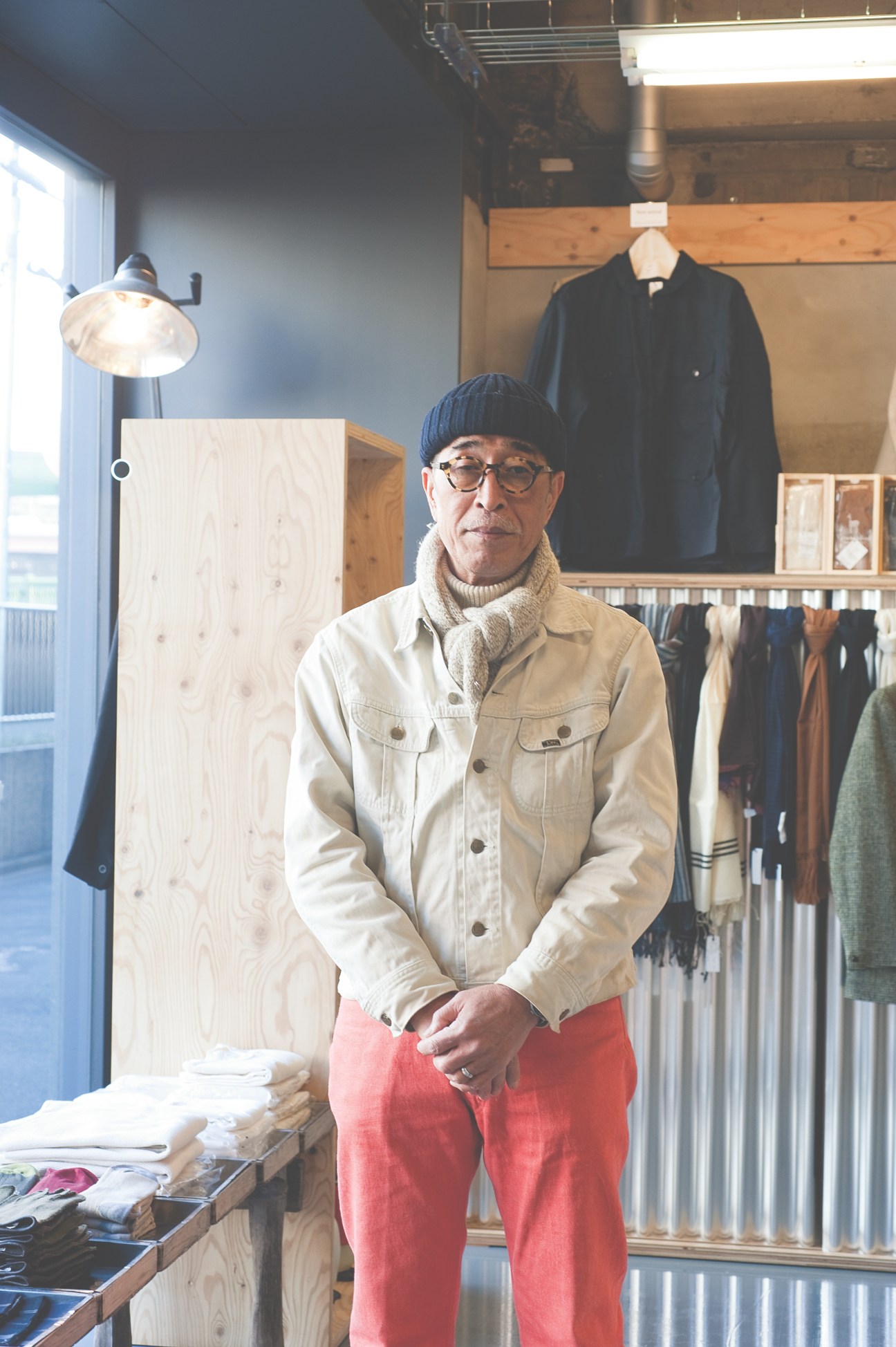 Shop assistant Ryuichi Nakamura stands in Anatomica's Tokyo store among clothing displays.