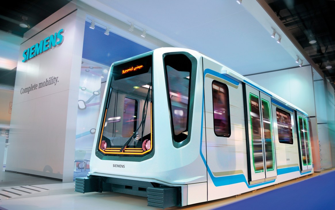 Siemens Inspiro metro train with white body, blue and yellow accents, and trapezoidal windows on display.